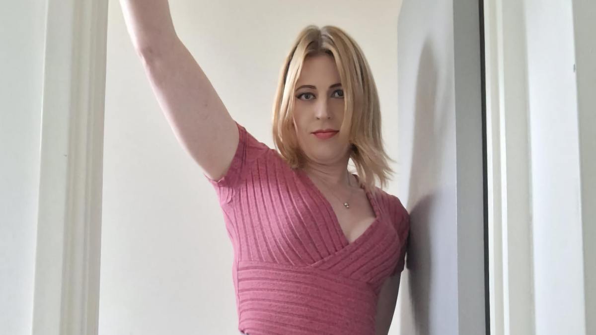 A cropped photo of Ami Foxx (Amelia) owner of Amelia's Angels, standing in a door frame, looking earnestly into the camera.